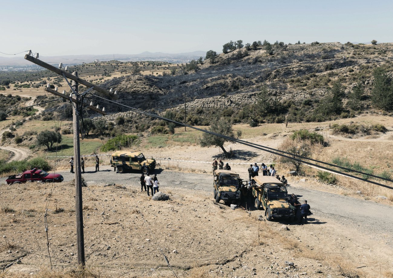 Members of the northern Cypriot security forces stand on a burnt portion of a slope where, according to officials, a suspected Russian-built missile exploded overnight on 1 July during an Israeli aerial raid in Syria. (Iakovos Hatzistavrou/AFP/ Getty Images)