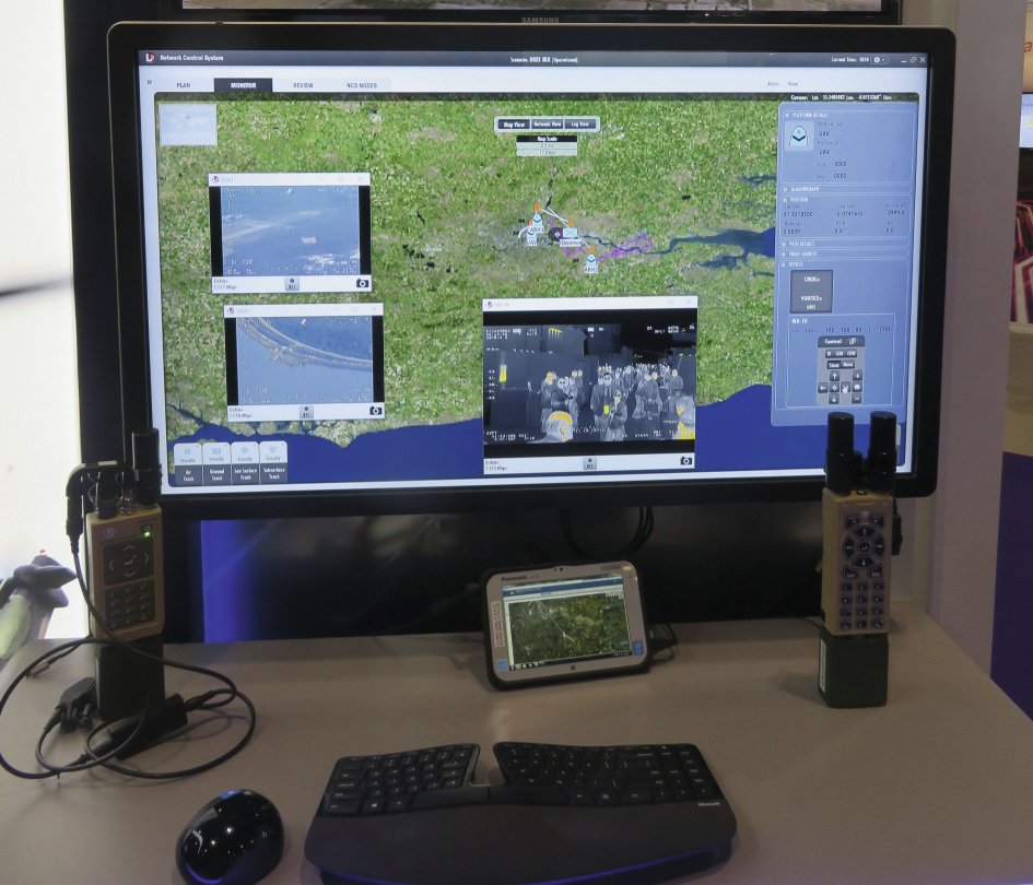 The L3Harris Technologies network control system for manned/unmanned teaming demonstrated at DSEI 2019. The images on the left of the situational awareness map are sensors from two attack helicopters, the image in the middle is from an L3 Wescam MX-10 in a UAV, and on the right is the UAV data. Below the screen are L3 ROVER devices for dismounted personnel. (Giles Ebbutt)