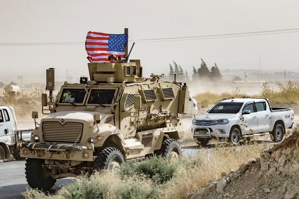 US troops patrol in the Syrian border town of Ras al-Ayn on 6 October, the day their withdrawal was announced by Donald Trump. (Delil Souleiman/AFP via Getty Images  )