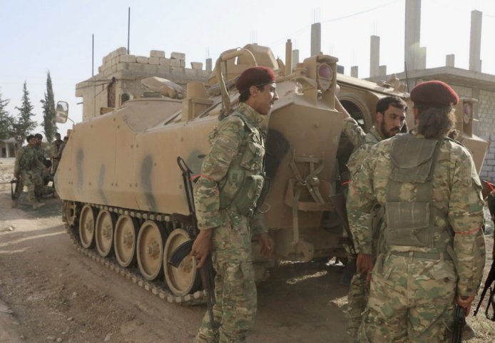 Turkish-backed Syrian fighters are seen with an ACV-15 APC in the Syrian border town of Tal Abyad on 10 October 2019. (Hisam el-Homsi/Anadolu Agency via Getty Images)