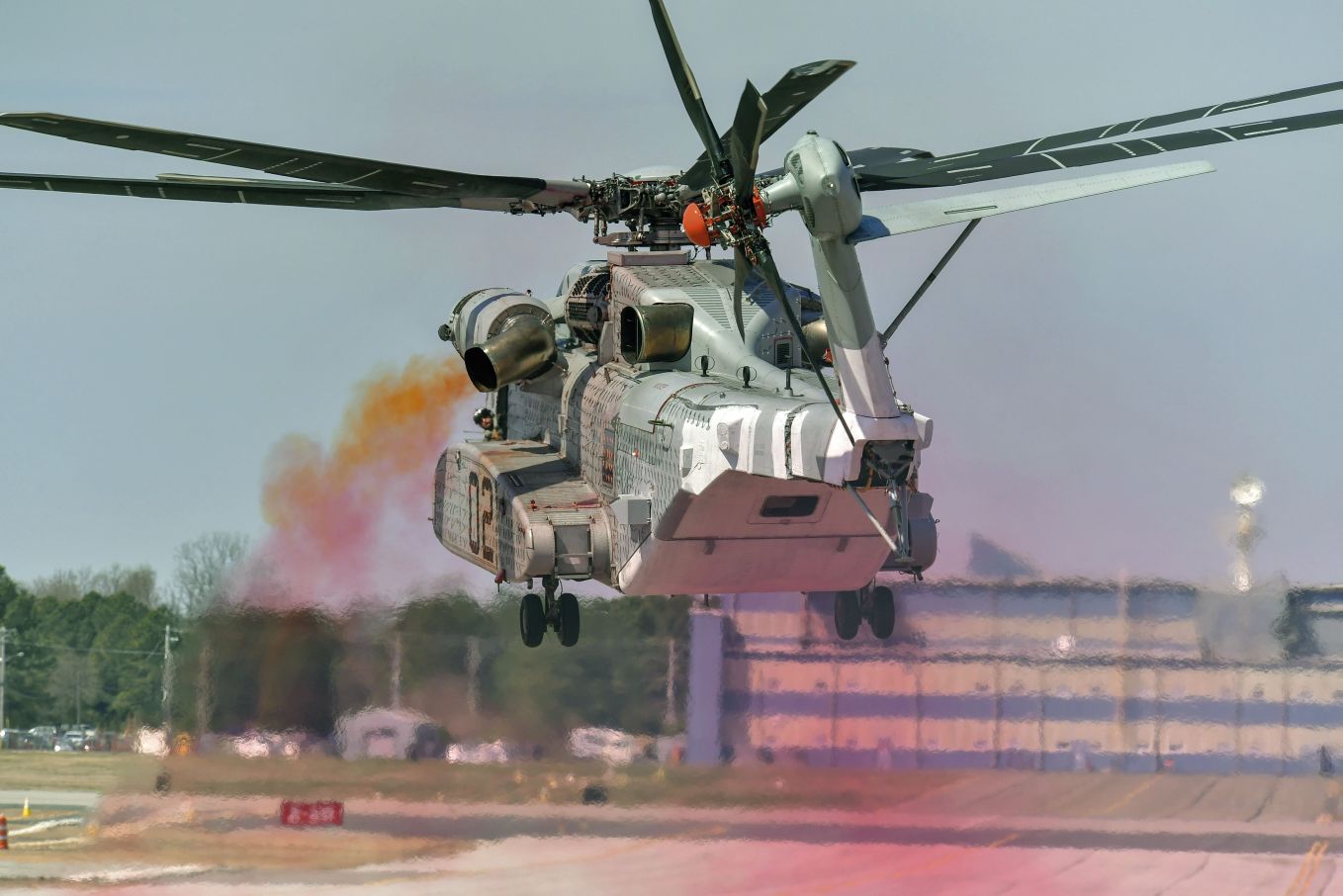 A CH-53K performs EGR testing on 4 April. The coloured oil smoke indicates rotor wake. (US Marine Corps)