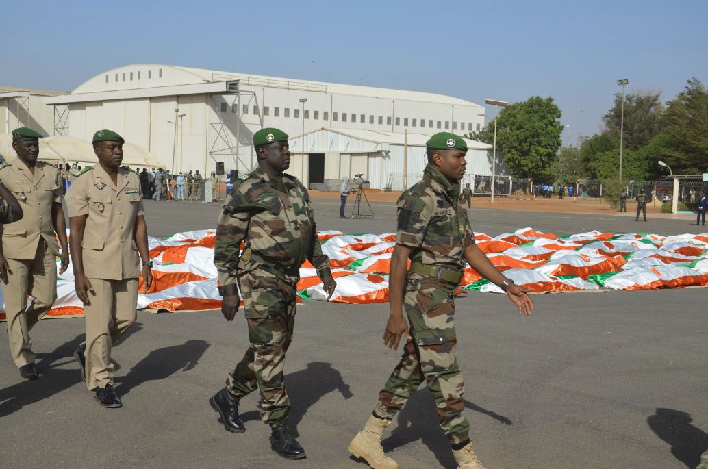 Nigerien military personnel walk past the corpses of soldiers killed in a 10 December 2019 attack on a military base in western Niger. (Boureima Hama/AFP via Getty Images )