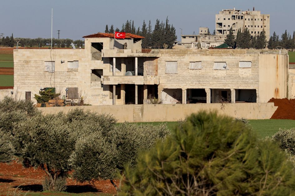 A Turkish flag flies over a building with a Turkish armoured vehicle parked outside north of Saraqib on 1 February. (Omar Haj Kadour /AFP via Getty Images )